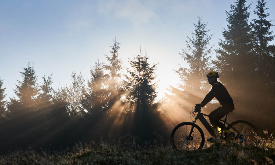 young-man-riding-bicycle-mountains-early-morning