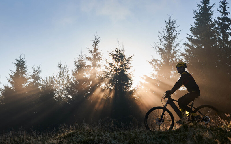young-man-riding-bicycle-mountains-early-morning